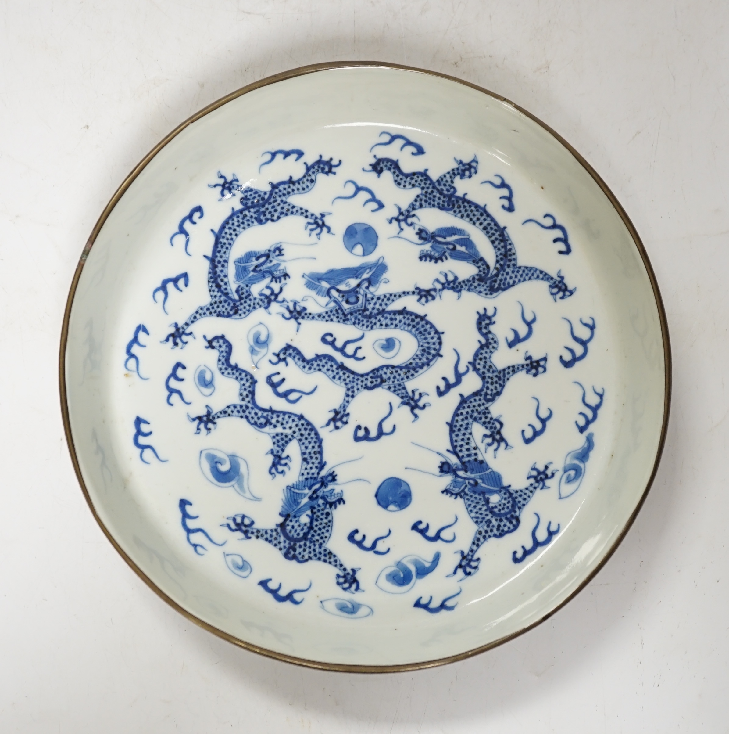 A Chinese blue and white ‘fire dragon’ dish, for the Vietnamese market, with copper bound rim, 19th century, four character mark. Condition - some minor glazing faults